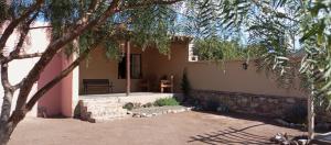 a house with a stone wall next to a yard at mirapampa in Maimará