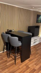 a black desk with chairs and a television in a room at Two bedroom apartement in Sogndal