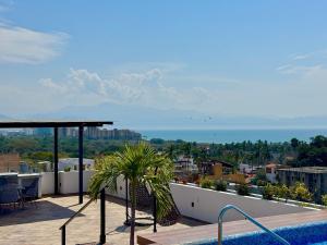 a balcony with a pool and a view of the city at 2BR Condo with Ocean View near beach in Bucerías