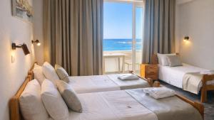 a hotel room with two beds with a view of the ocean at Klinakis Beach Hotel in Chania +280 photos