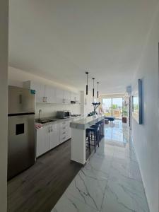 a kitchen with white cabinets and a table in it at 2BR Condo with Ocean View near beach in Bucerías