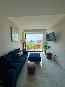 a living room with a blue couch and a tv at 2BR Condo with Ocean View near beach in Bucerías