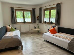 a living room with two beds and a couch at Landhaus Irena - Familienfreundliches Ferienhaus an der Zillerpromenade mit Bergblick in Ramsau im Zillertal