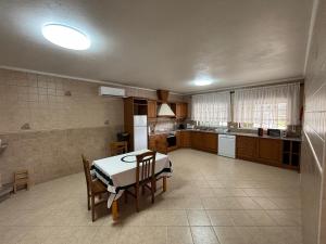 a large kitchen with a table and chairs in it at Casa dos Neto Carriço in Anadia