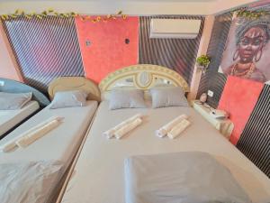a bedroom with two beds and a painting on the wall at vila darkoni in Bijeljina