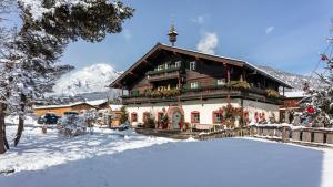 a house in the snow with a snow covered yard at Appartement & Ferienwohnung am Baby & Kinderbauerhof Stefflhof in Saalfelden am Steinernen Meer