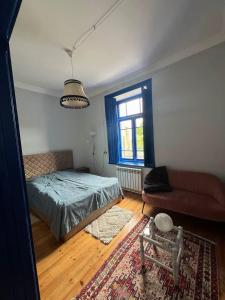 a bedroom with a bed and a couch and a window at Green Vibe Guesthouse in Vanadzor