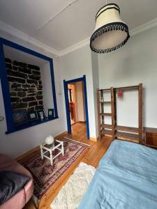 a bedroom with a blue bed and a stone wall at Green Vibe Guesthouse in Vanadzor +4 photos