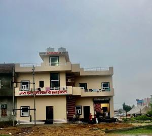 a building with people sitting outside of it at Hotel rahul prime in Gogameri