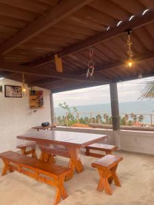 a picnic table with benches and a view of the ocean at Casa brisa do mar icapuí in Icapuí