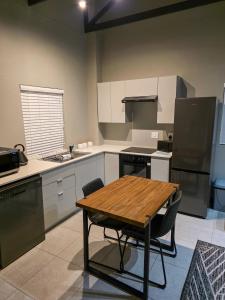 a kitchen with a wooden table and a table and chairs at West Coast Apartment 85 in Langebaan
