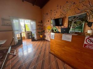 a room with a counter with a tv on a wall at Damaris Hostel in Puerto Iguazú