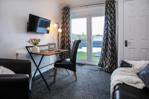 a room with a desk with a chair and a window at Penrhos Walks in Holyhead