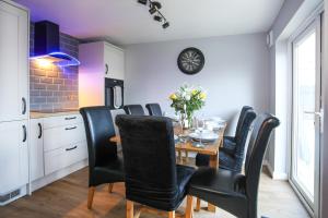 a dining room with a table and black chairs at Penrhos Walks in Holyhead