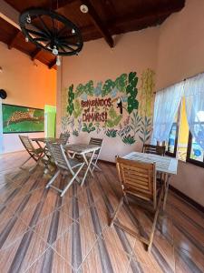 a room with chairs and tables and a mural on the wall at Damaris Hostel in Puerto Iguazú