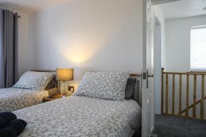 a bedroom with two beds and a window at Penrhos Walks in Holyhead