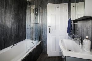 a bathroom with a white tub and a sink at Penrhos Walks in Holyhead +51 photos