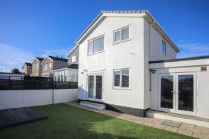 a white house with a lawn in front of it at Penrhos Walks in Holyhead