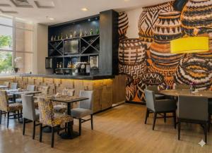 a restaurant with tables and chairs and a bar at Airport Gru Flats in Guarulhos