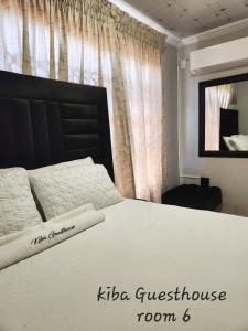 a bedroom with a large white bed with a black headboard at Kiba guest house in Marble Hall