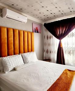 a bedroom with a white bed with an orange wall at Kiba guest house in Marble Hall