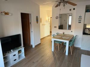 a living room with a dining room table and a television at Apartamento Torrenueva en playa 4 planta in Torrenueva