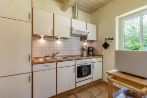 a kitchen with white cabinets and a sink at Ferienhaus 4 in Fehmarn