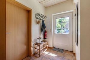 a hallway with a white door and a window at Ferienhaus 4 in Fehmarn +19 photos