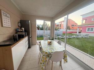 a kitchen and dining room with a table and chairs at Verdizela Suites in Corroios +6 photos