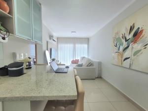 a kitchen and living room with a laptop on a counter at GALILEU - Apartamento próximo à UniCPO, Mondelli, USP, FACOP e FIASP in Bauru