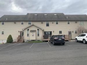 a large building with cars parked in a parking lot at Caribbean Deck Estate in Effort