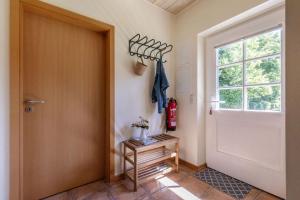 a hallway with a door and a table with a fire extinguisher at Ferienhaus 3 in Fehmarn +17 photos