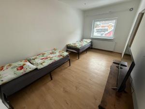two beds in a room with a window at Schelder Zimmer in Dillenburg +8 photos