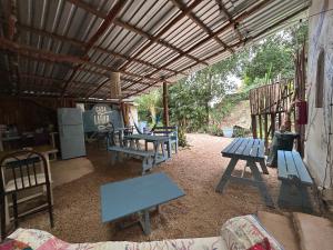 a group of picnic tables and benches under a roof at Hostalito Lahar in Bacalar