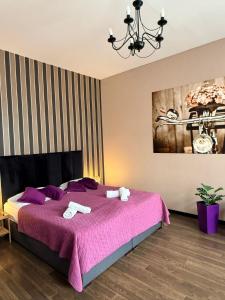 a bedroom with a purple bed with towels on it at Harmonica Studio in Nowy Sącz
