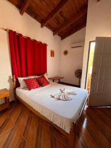 a bedroom with a large bed with red curtains at Damaris Hostel in Puerto Iguazú +24 photos