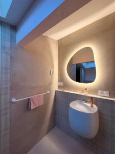 a bathroom with a white sink and a mirror at La P'tite Bicoque in Doizieux