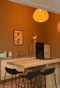 a kitchen with a counter with four bar stools at La P'tite Bicoque in Doizieux