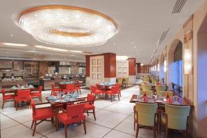 a restaurant with tables and chairs and a large chandelier at فلل خاصة في آي بي فاخرة - فندق وأبراج مكة in Mecca