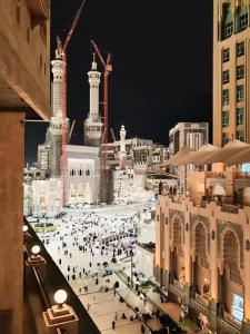 a group of people walking around a city at night at فلل خاصة في آي بي فاخرة - فندق وأبراج مكة in Mecca