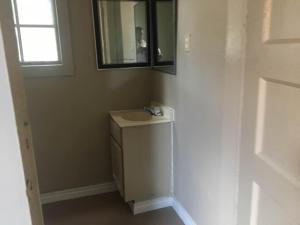 a bathroom with a sink and a mirror at 424 E Levee Sreet #1 in Brownsville