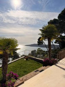 a view of the ocean from a resort with palm trees at Blueview Villa in Llafranc