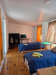 a room with three beds and a table and a television at Casa Terminal in Paraná