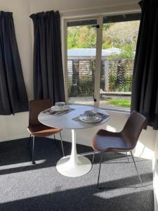 a table and chairs in a room with a window at Property close to the beach in Nelson