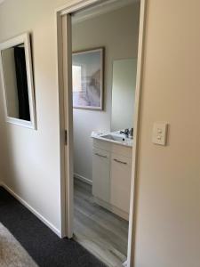a bathroom with a sink and a mirror at Property close to the beach in Nelson +7 photos