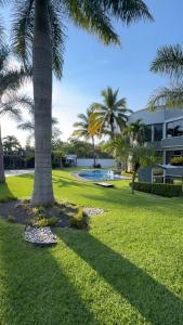 a park with palm trees and a building at Residencia privada de 10 habitaciones para 20 personas in Chiconcuac