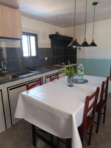 a kitchen with a white table and some chairs at Akany Sahoby in Antananarivo