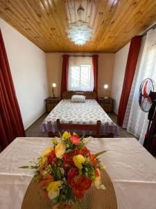 a bedroom with a bed and a bouquet of flowers on a table at Akany Sahoby in Antananarivo +2 photos