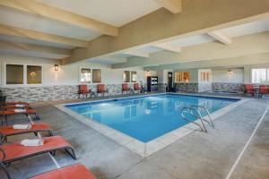 a pool in a hotel with chairs and tables at Best Western Blackfoot Inn in Blackfoot