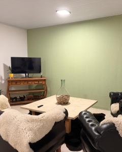 a living room with two chairs and a table and a television at Hostel em Jaguarão in Jaguarão